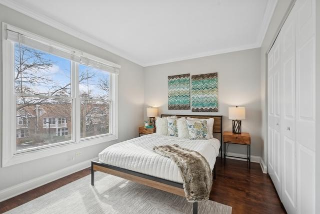 bedroom with a closet, crown molding, baseboards, and wood finished floors