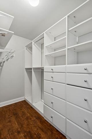 spacious closet with dark wood-style flooring