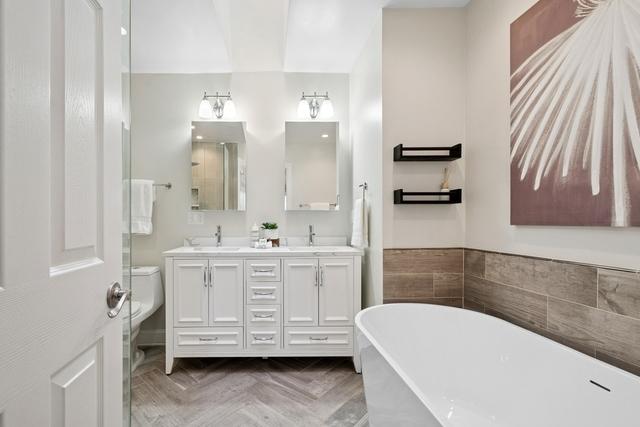 bathroom featuring a freestanding bath, double vanity, and a sink