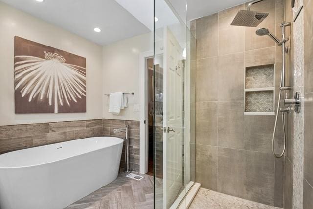 full bath featuring a soaking tub, a shower stall, and recessed lighting