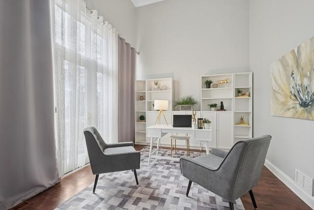 living area featuring visible vents, baseboards, and wood finished floors