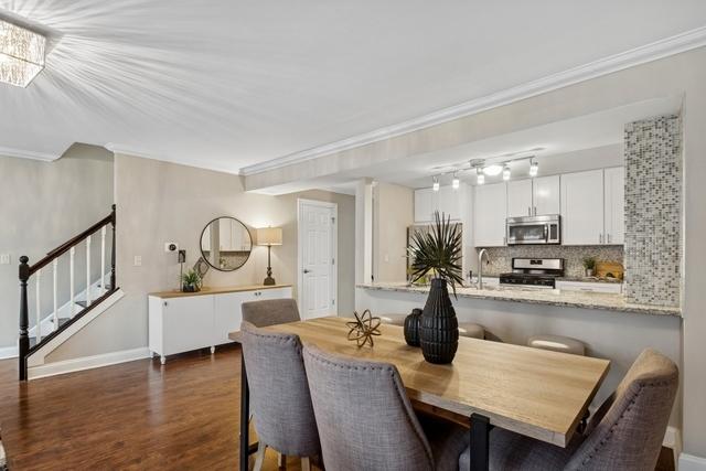 dining space featuring baseboards, stairway, dark wood finished floors, and ornamental molding