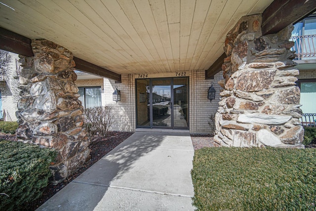 doorway to property featuring brick siding