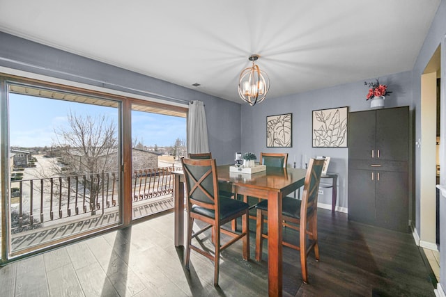 dining space featuring wood finished floors, visible vents, baseboards, and an inviting chandelier