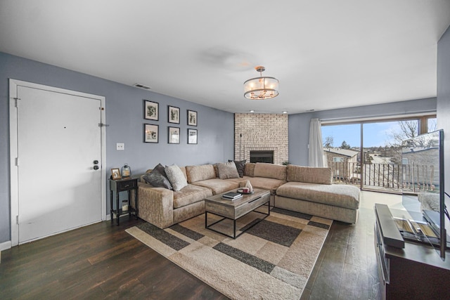 living area featuring a fireplace, visible vents, and dark wood-type flooring