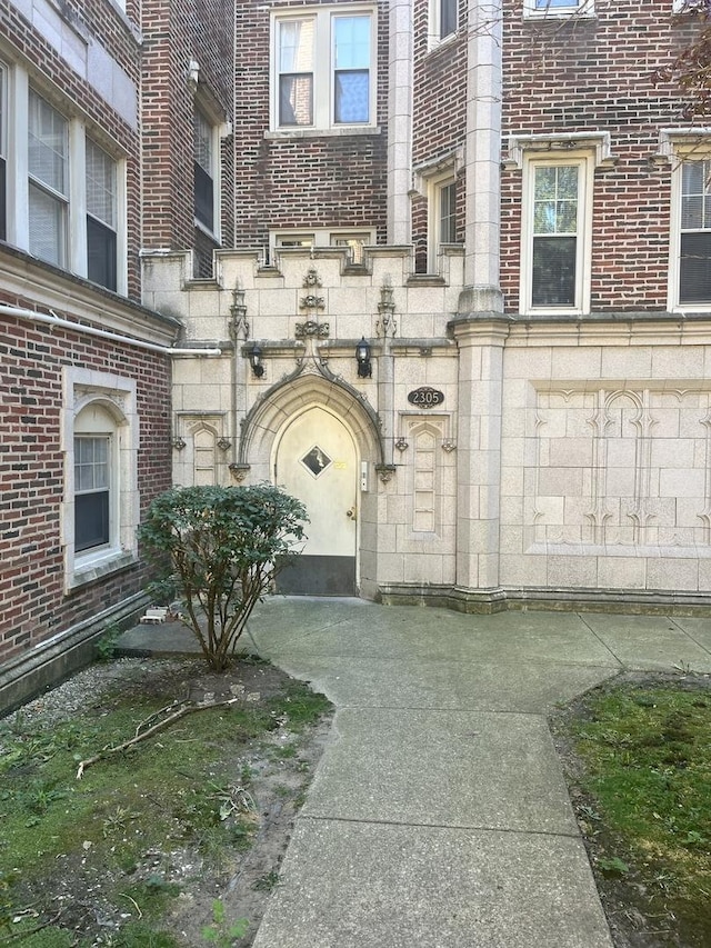 entrance to property featuring stone siding and brick siding