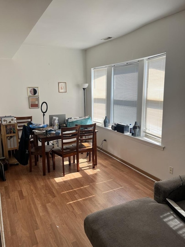 dining area featuring plenty of natural light, wood finished floors, and visible vents