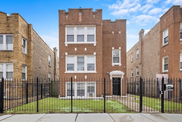 view of front of home with a fenced front yard, a front yard, and brick siding