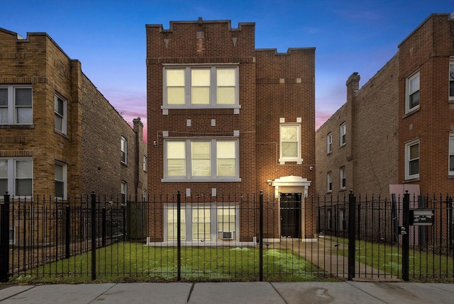 view of front facade with a fenced front yard and brick siding