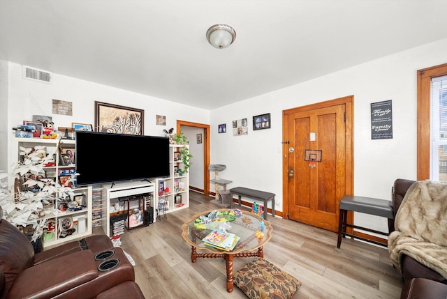 living area with light wood finished floors, baseboards, and visible vents