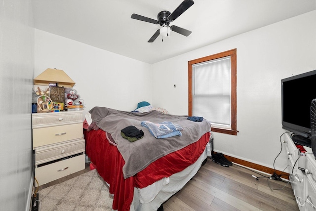 bedroom featuring a ceiling fan, light wood-type flooring, and baseboards