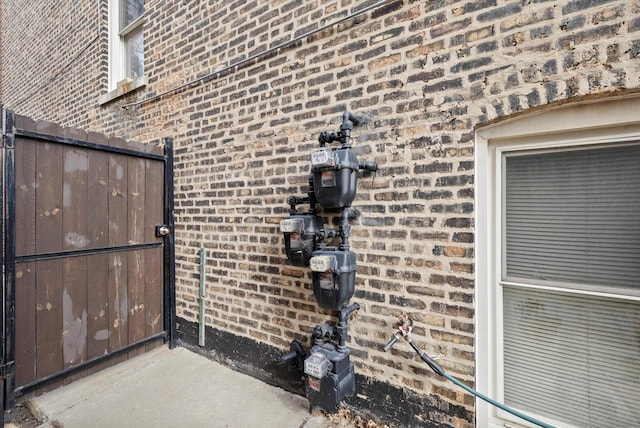 exterior details featuring gas meter and brick siding