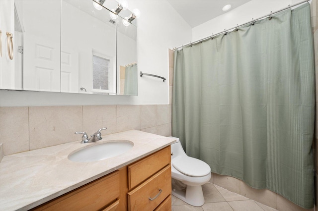 bathroom featuring curtained shower, toilet, tile walls, vanity, and tile patterned floors