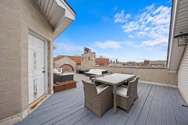 wooden deck with a view of city, outdoor dining area, and an outdoor living space