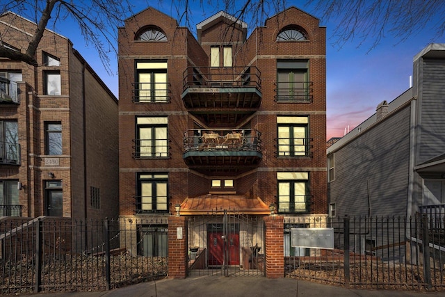 property at dusk featuring a fenced front yard