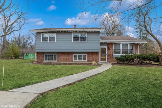 split level home featuring brick siding, a chimney, and a front yard