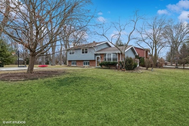 split level home with brick siding and a front lawn