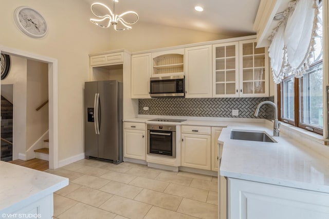 kitchen featuring a sink, vaulted ceiling, stainless steel appliances, open shelves, and backsplash