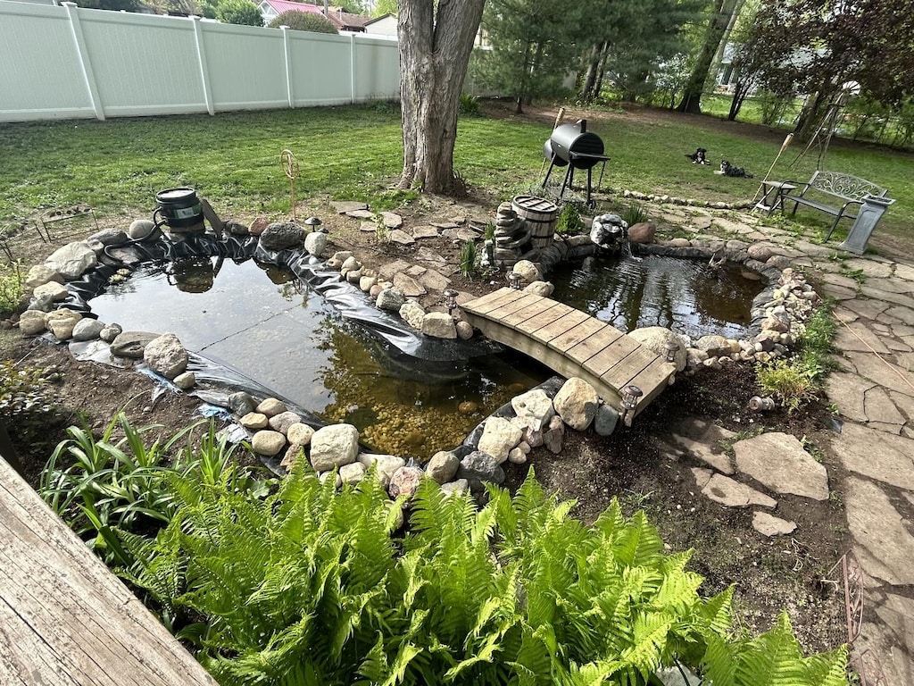 exterior space with a garden pond and fence