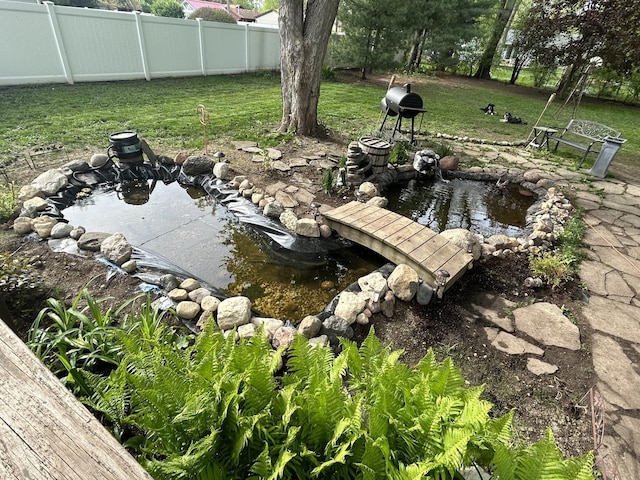 exterior space with a garden pond and fence