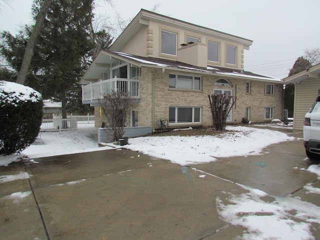 view of front of property featuring brick siding and fence