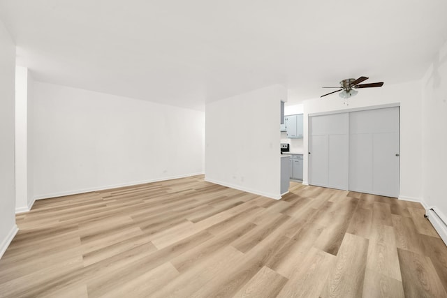 unfurnished living room with a ceiling fan, light wood-type flooring, and baseboards