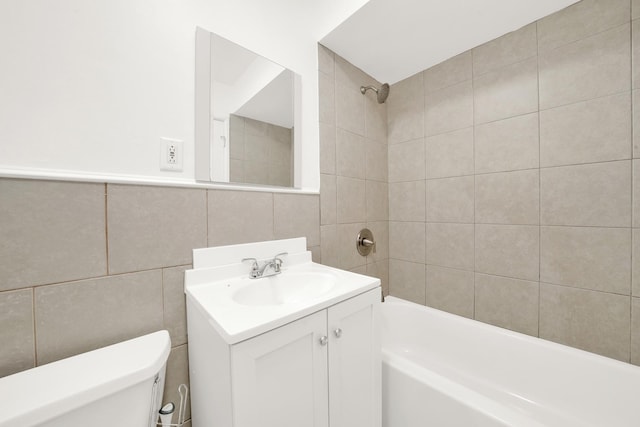 bathroom with  shower combination, tile walls, vanity, and toilet