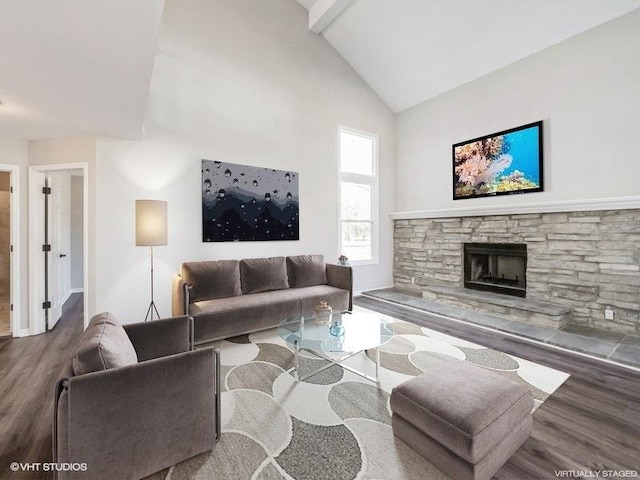 living room with beamed ceiling, high vaulted ceiling, wood finished floors, and a fireplace