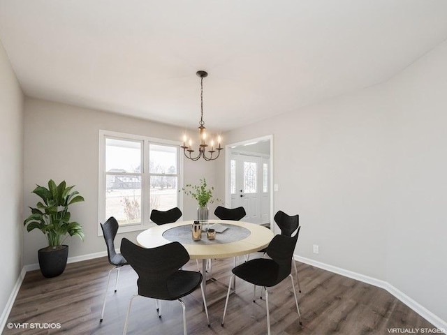 dining area featuring a notable chandelier, baseboards, and wood finished floors