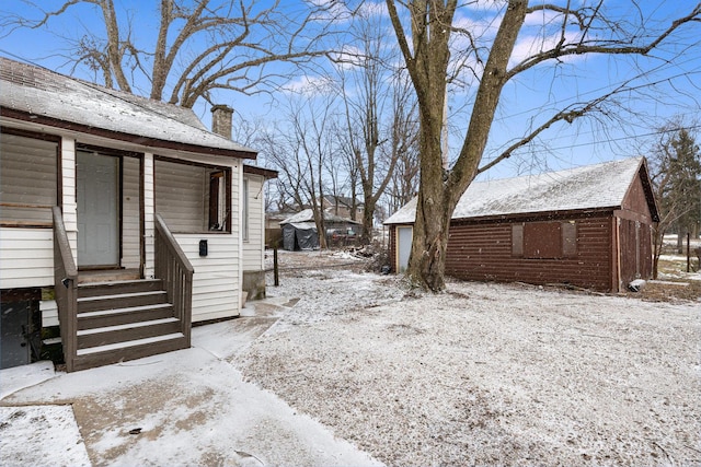 view of snow covered exterior with a chimney