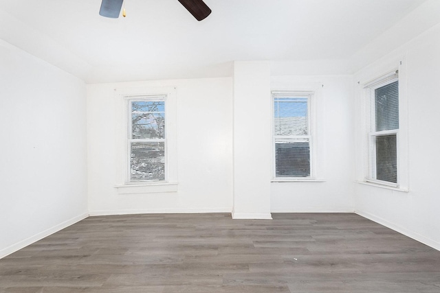 empty room featuring wood finished floors, a ceiling fan, and baseboards