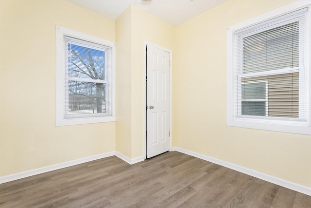 spare room featuring wood finished floors and baseboards