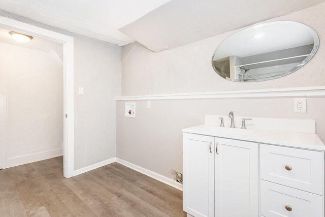 bathroom with vanity, baseboards, and wood finished floors