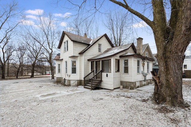 view of front of property featuring entry steps and a chimney