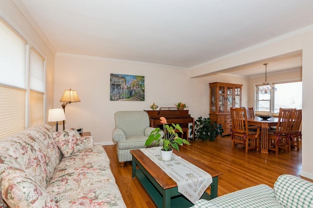 living area with a notable chandelier, wood finished floors, and crown molding