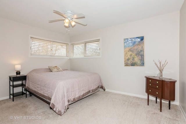 bedroom featuring baseboards, light colored carpet, and ceiling fan