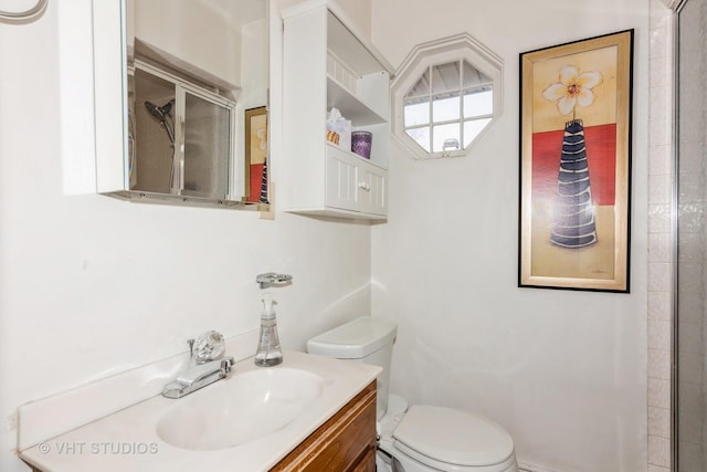 bathroom featuring vanity, toilet, and walk in shower