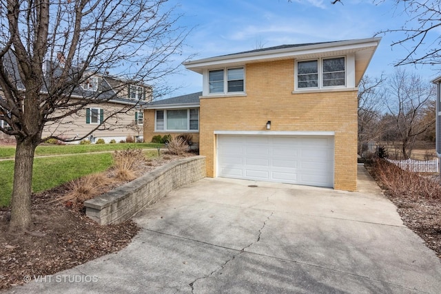 tri-level home featuring brick siding, concrete driveway, and a garage