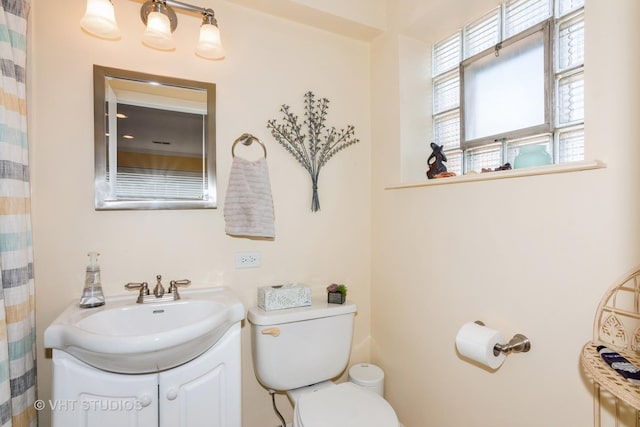 full bathroom with vanity, toilet, and a wealth of natural light