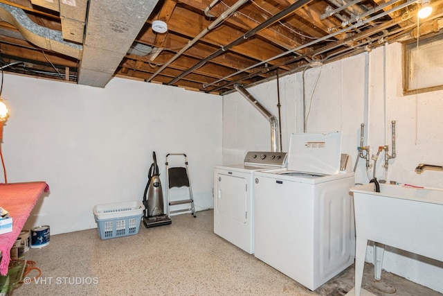 laundry area featuring a sink, laundry area, and washer and clothes dryer