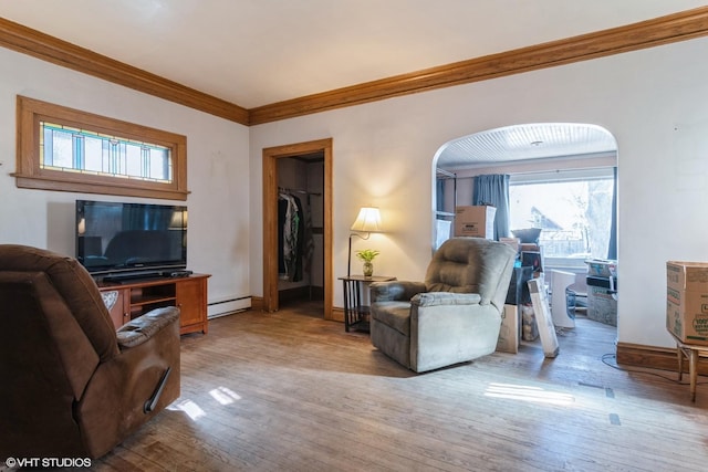 living room featuring a baseboard heating unit, light wood-type flooring, ornamental molding, and arched walkways