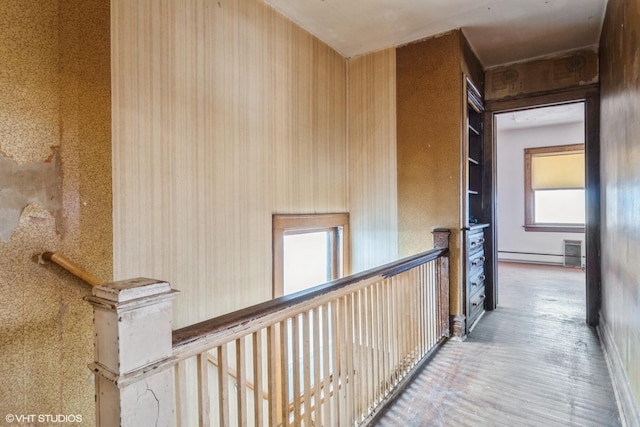 hallway with baseboard heating and wood finished floors