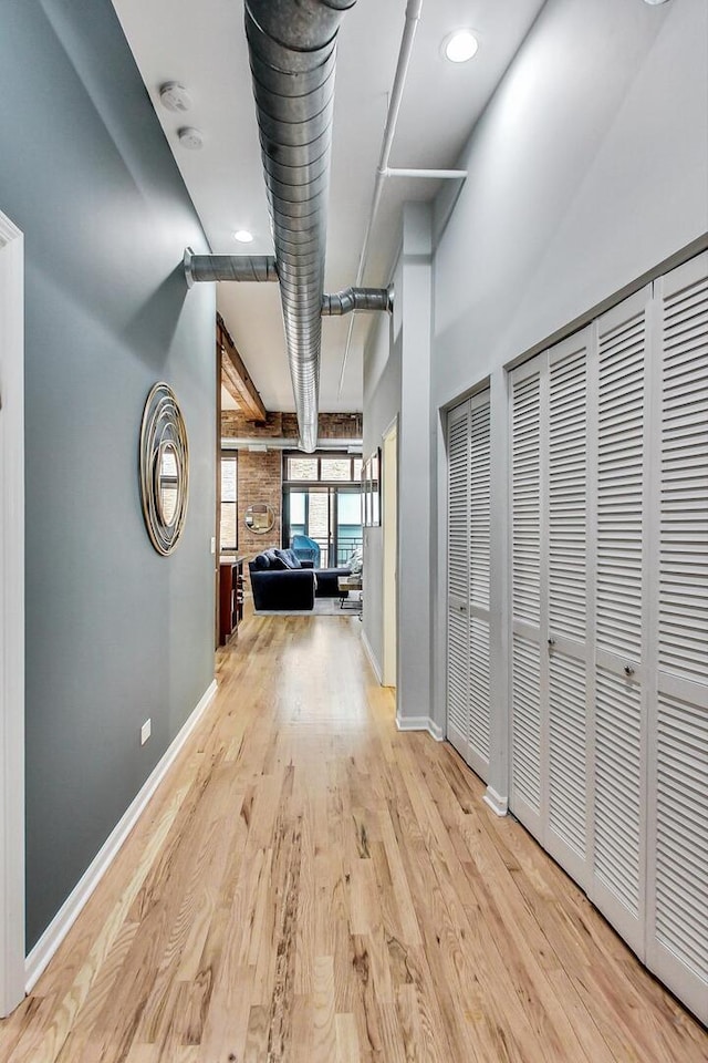 hallway featuring light wood-type flooring and baseboards