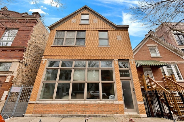 view of front of property featuring a fenced front yard and brick siding