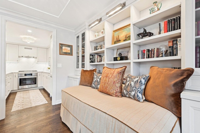 sitting room featuring ornamental molding and dark wood-type flooring