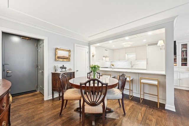 dining room featuring ornamental molding, dark wood-type flooring, recessed lighting, and baseboards