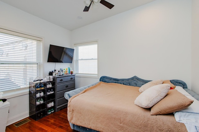 bedroom featuring vaulted ceiling, multiple windows, wood finished floors, and visible vents