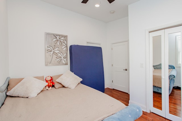 bedroom with wood finished floors, a ceiling fan, baseboards, french doors, and a closet