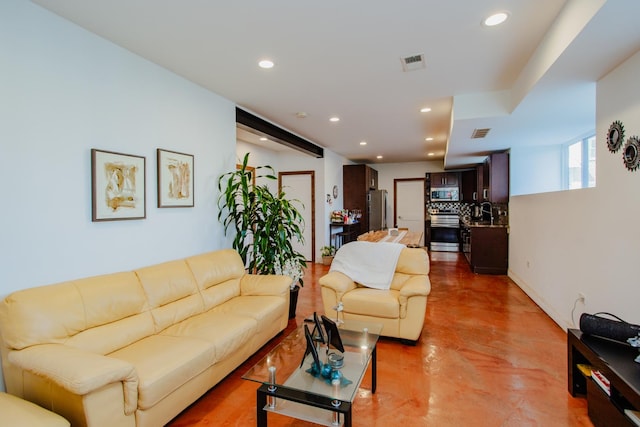 living room with concrete floors, visible vents, and recessed lighting