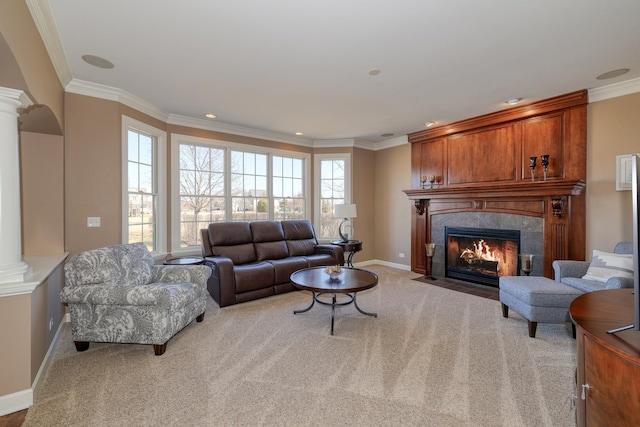 carpeted living room with a premium fireplace, ornamental molding, baseboards, and decorative columns